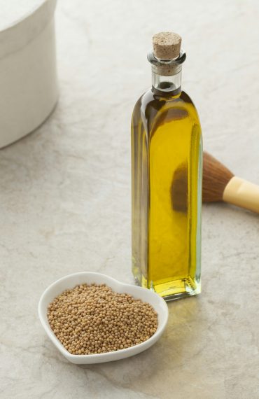 Bottle with mustard oil and seeds