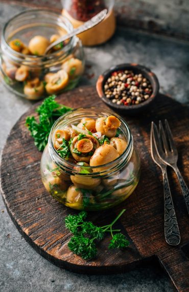 Homemade pickled mushrooms in a jar with spices